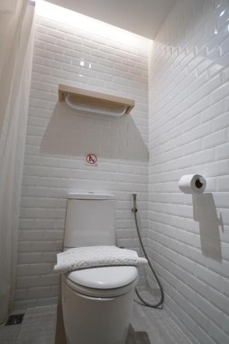 a white bathroom with a toilet with a hose at W 21 Hotel Bangkok in Bangkok
