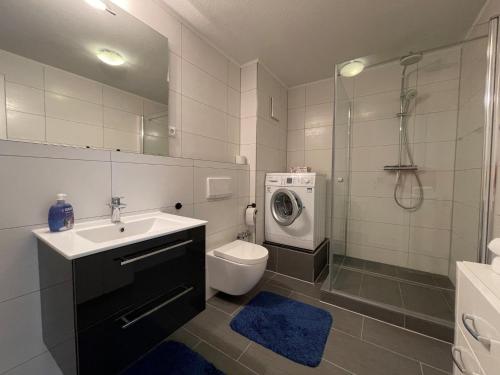 ein Badezimmer mit einem Waschbecken und einer Waschmaschine in der Unterkunft Apartment 12 in Wilhelmshaven
