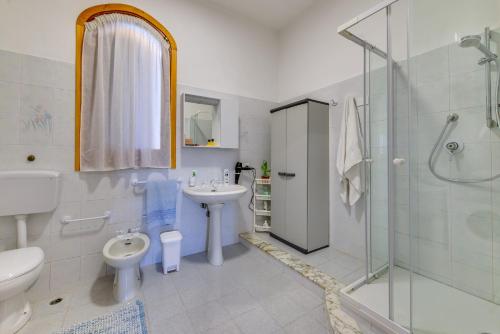 een badkamer met een wastafel, een toilet en een douche bij Matisé Home Relax in Sciacca
