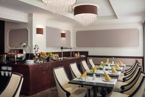 a dining room with tables and chairs and a bar at Boutique Hotel Saxonia in Karlovy Vary