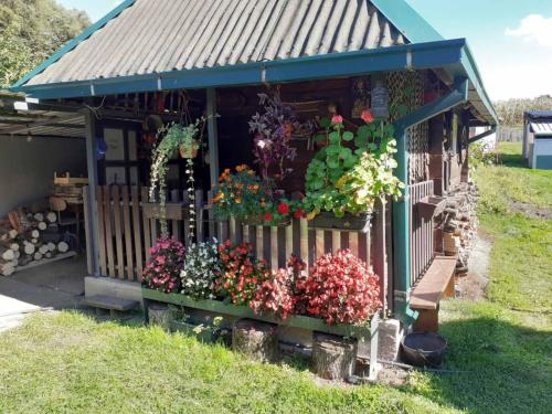 a small house with flowers on the porch at Pantića avlija - Ethno household in Požega