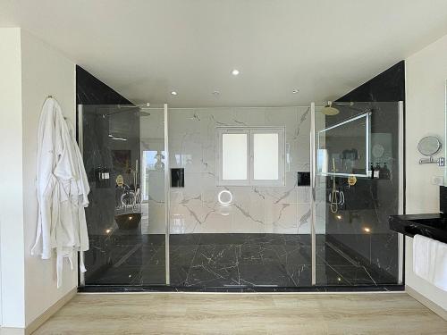 a bathroom with a shower with a glass door at 4AS Spa Paris in Verdelot