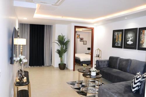 a living room with a couch and a table at Gold Crest Luxurious Apartment in Lahore in Lahore