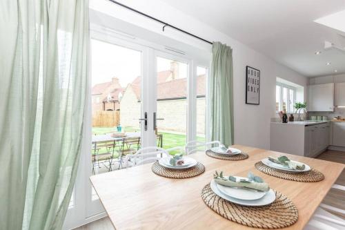 a dining room with a table and a large window at Oxfordshire Living - The Vanderbilt - Woodstock in Woodstock