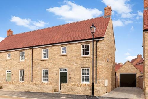 a large brick building with a red roof at Oxfordshire Living - The Vanderbilt - Woodstock in Woodstock