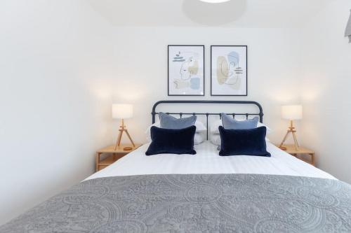 a bedroom with a large bed with blue pillows at Oxfordshire Living - The Vanderbilt - Woodstock in Woodstock