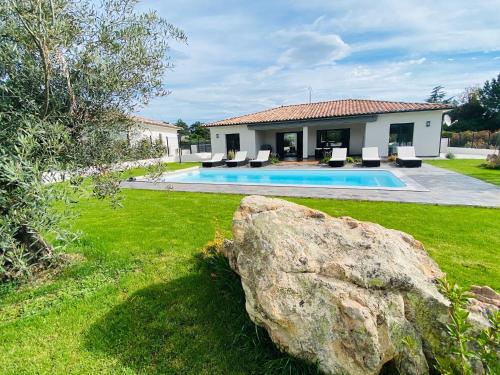 une maison avec une piscine et un grand rocher dans l'établissement Capella Suttana, à Ventiseri