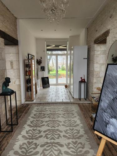 a living room with a hallway with a chandelier at Maison Laurenza/ La Liversoise in Saint-Jean-de-Liversay
