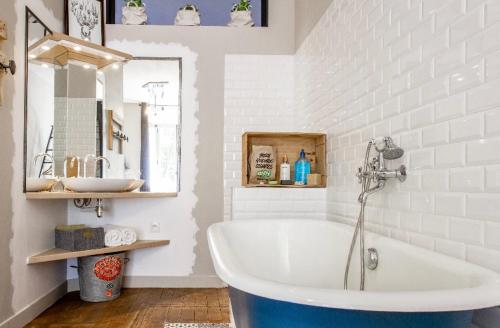 une salle de bain blanche avec une baignoire et un miroir dans l'établissement **** L'Odyssée Toulouse ****, à Toulouse