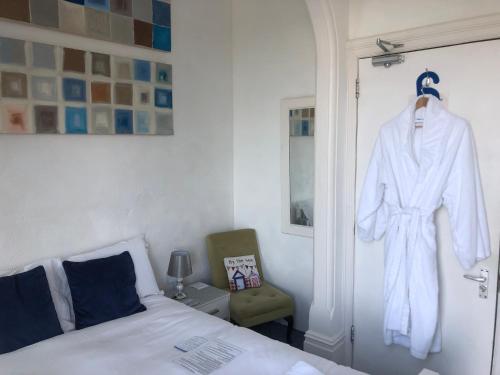 a bedroom with a white robe hanging on a door at Seaview Sanctuary in Eastbourne