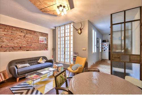 un salon avec un canapé et une table dans l'établissement **** L'Odyssée Toulouse ****, à Toulouse