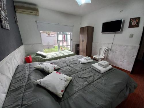 1 dormitorio con 2 camas y TV de pantalla plana en Sol y Luna B&B en Monte Grande