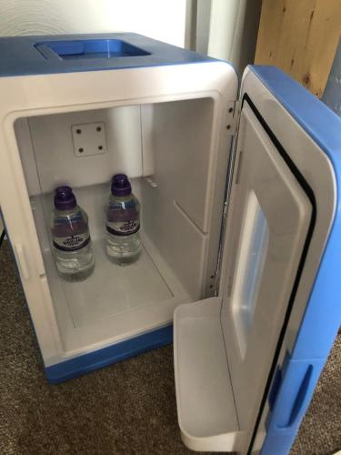 an open refrigerator with two bottles of water in it at Seaview Sanctuary in Eastbourne