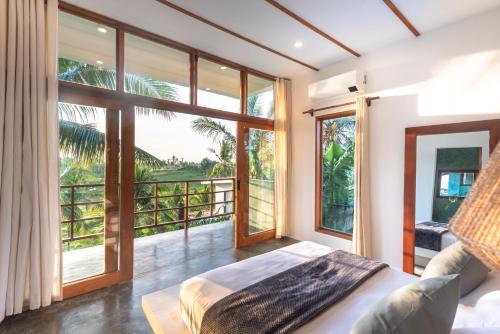 a bedroom with a bed and a large window at Tanaw Villas in General Luna