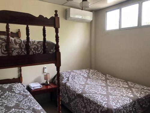 - une chambre avec un lit, une fenêtre et un couvre-lit dans l'établissement Casa en Ballenita: Piscina, Vóley, BBQ y Mar Cerca, à Ballenita