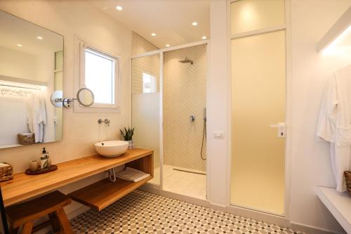 a bathroom with a walk in shower and a sink at Galini Hotel in Mýkonos City