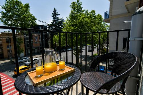 two glasses of orange juice on a table on a balcony at Euro Hotel Kutaisi in Kutaisi