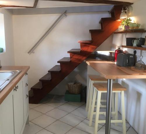 a kitchen with a wooden staircase in a room at Historic school room in Helston