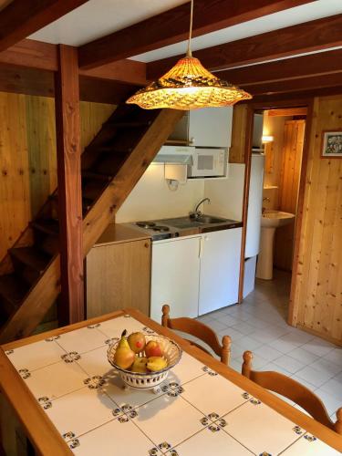une cuisine avec une table avec un bol de fruits dessus dans l'établissement Chalet dans le parc d'un manoir du XIXème, à Anglès