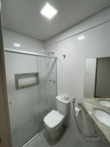 uma casa de banho com um WC, um chuveiro e um lavatório. em Xikus Palace Hotel em Guanhães