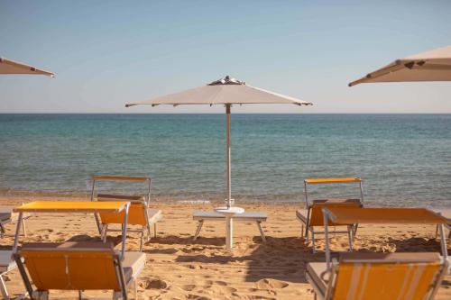 a group of chairs and an umbrella on the beach at Sei Stelle Mama in Polignano a Mare