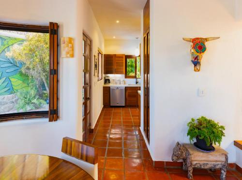 a hallway of a house with a plant on a table at Villa Monte in Sayulita