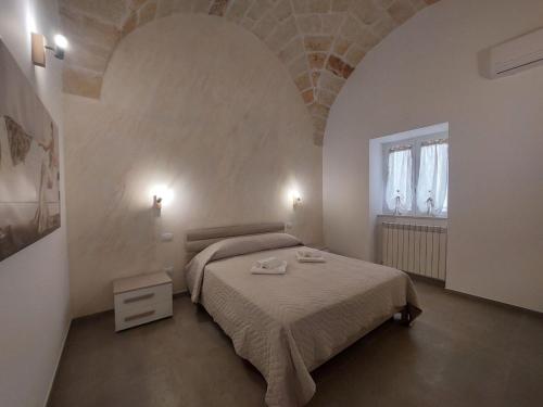 a bedroom with a large bed and a window at Tropical Palm Villa in Monopoli