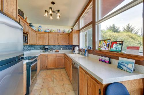a kitchen with wooden cabinets and a large window at McKinleyville Getaway with Hot Tub and Ocean Views! in McKinleyville