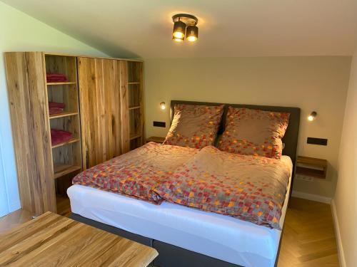- une chambre avec un lit et une étagère dans l'établissement Apartment Perle am See - Wohnen auf Zeit - Homeoffice - nah am See - buchbar ab 28 Nächte, à Schliersee