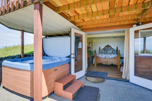 ein Haus mit einer Badewanne auf einer Veranda mit einem Bett in der Unterkunft McKinleyville Getaway with Hot Tub and Ocean Views! in McKinleyville