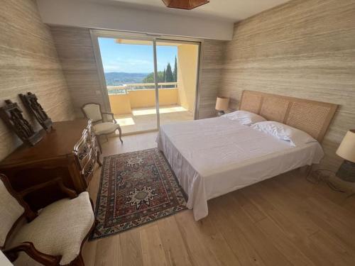 une chambre avec un lit, un bureau et une fenêtre dans l'établissement Appartement Terrasse, à Grasse