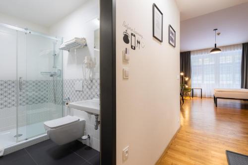 a bathroom with a shower and a toilet and a sink at EA ApartHotel Melantrich in Prague