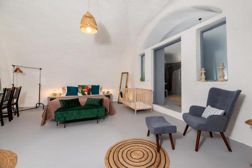 a living room with a bed and a couch and chairs at 1812 Caves 'n Mansion in Karterados