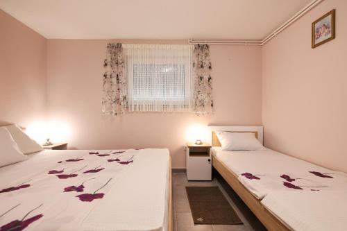 2 camas en una habitación con flores en las sábanas en Two Bedroom Apartment Sunset Vir, en Vir