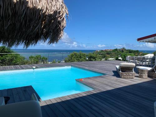 a swimming pool on a deck with a view of the ocean at Villa lagon Boipeba in Le François