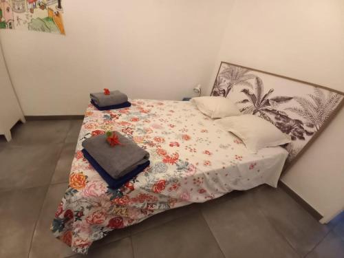 ein Bett mit einer Decke und Kissen darauf in der Unterkunft Villa lagon Boipeba in Le François