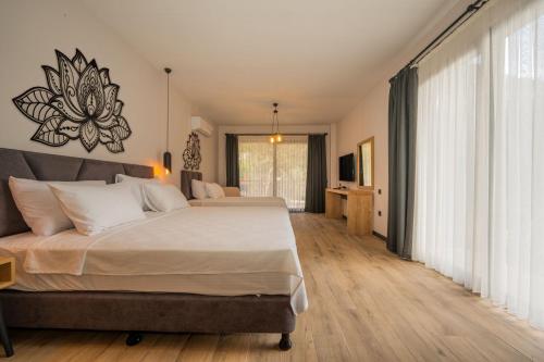 a bedroom with two beds and a large window at Sea Valley Lodge in Faralya