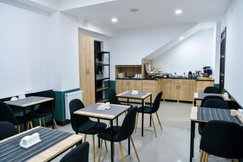 a restaurant with tables and chairs and a kitchen at Euro Hotel Kutaisi in Kutaisi