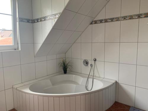 y baño de azulejos blancos con bañera blanca. en Wohnung 3 in der 1.Etage, en Hannover