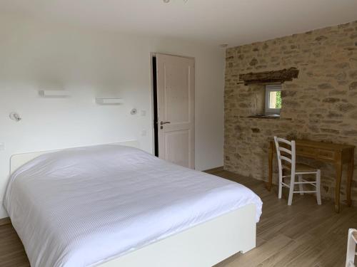 a bedroom with a bed and a table and a desk at La Combe aux Fées in Saint-Côme-dʼOlt