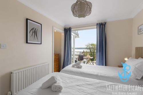 two beds in a bedroom with a view of the ocean at Stella Marina in Paignton