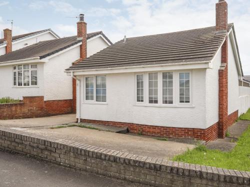 a white and red house with a brick at 31 Sisial Y Mor in Rhosneigr