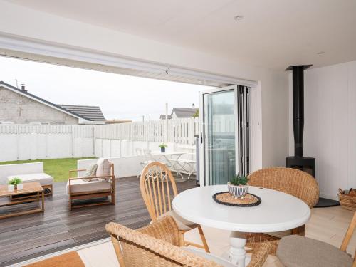 a living room with a white table and chairs at 31 Sisial Y Mor in Rhosneigr