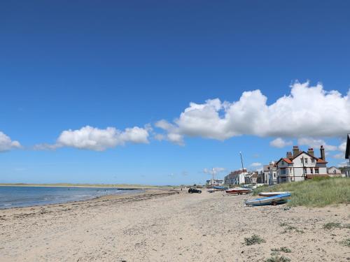 a beach with boats on the sand and a house at 31 Sisial Y Mor in Rhosneigr