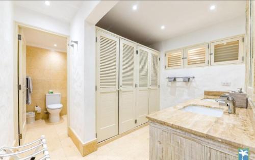 een badkamer met een wastafel en een toilet bij Holiday Villa 19 in La Romana