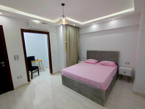 - une chambre dotée d'un lit avec des oreillers roses dans l'établissement Cozy Modern Apartment In El-Nozha, au Caire