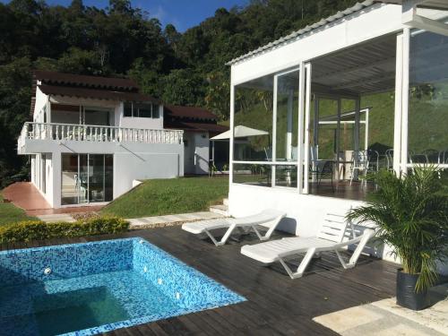 a villa with a swimming pool and a house at La Casa de la Montaña in La Vega