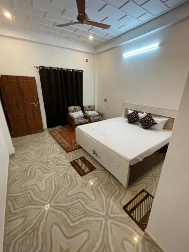 een slaapkamer met een bed en een plafondventilator bij Govind Atithi Grah in Ayodhya