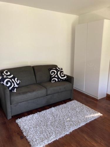 un salon avec un canapé gris et un tapis blanc dans l'établissement Le Trolle, à Saint-Pons