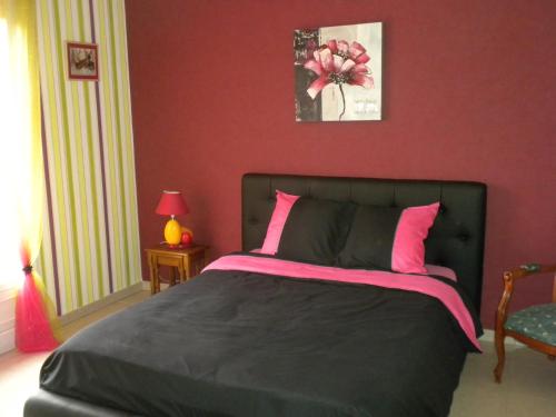 a bedroom with a bed with a red wall at L'Escapade in Vertus